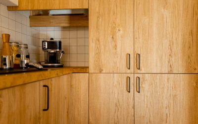 Close-up of kitchen facades made of oak veneer with black hadles