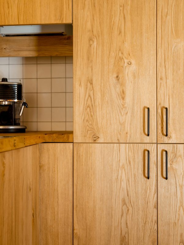 Close-up of kitchen facades made of oak veneer with black hadles